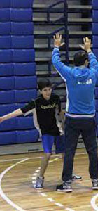 imagen de un niño practicando basquetbol guiado por un adulto