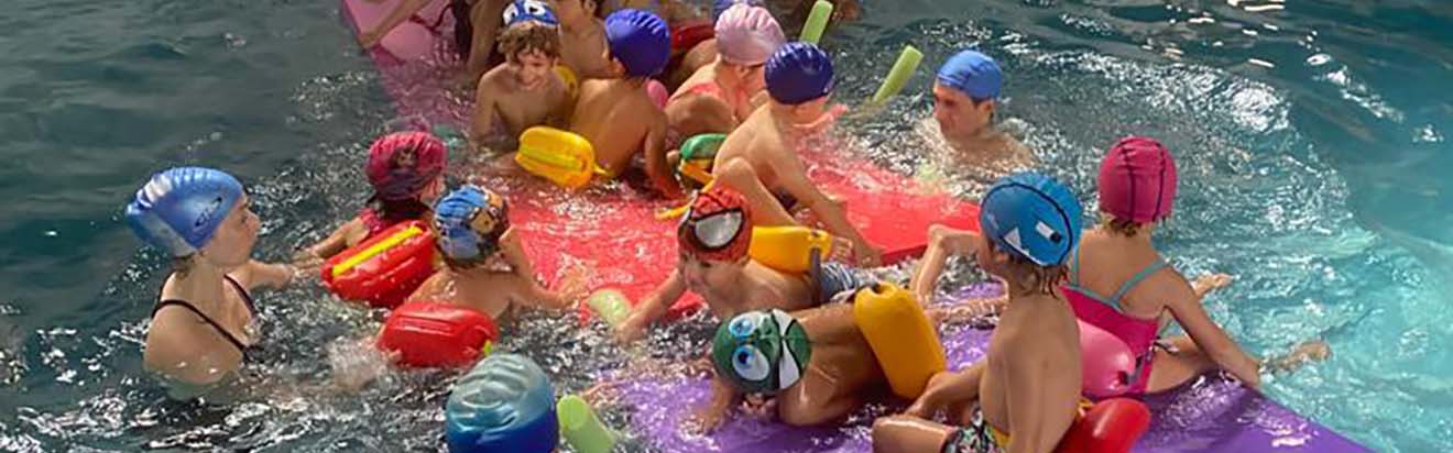 niños pequeños nadando en la piscina